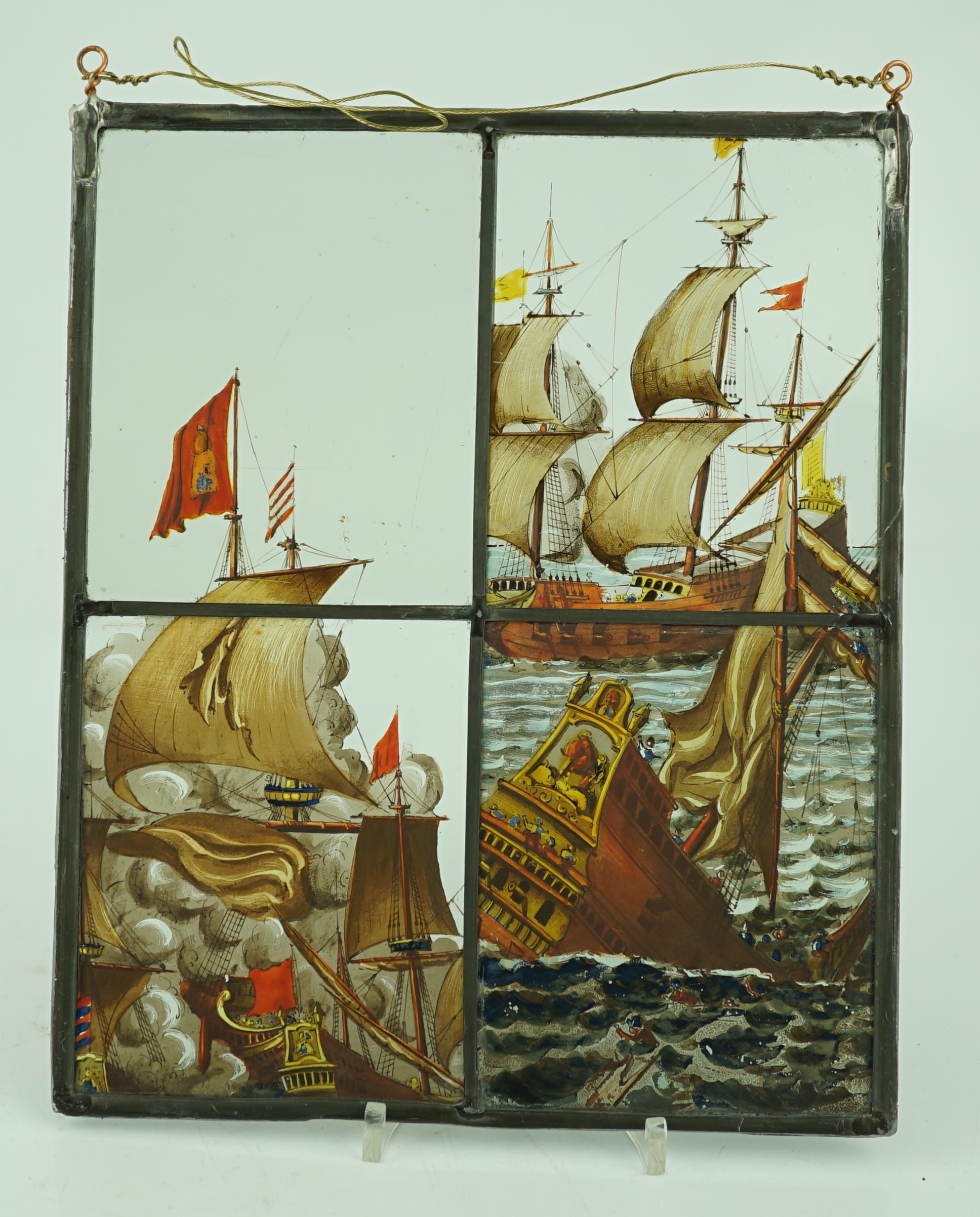 A 18th century Dutch stained glass panel made from four sections depicting a shipwreck and the sails of a fighting galleon, overall 28 x 23cm